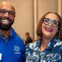 Two people at event, giving big smiles to the camera